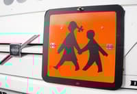 Voznik šolskega avtobusa otroku povozil nogo in odpeljal