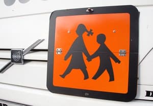 Voznik šolskega avtobusa otroku povozil nogo in odpeljal