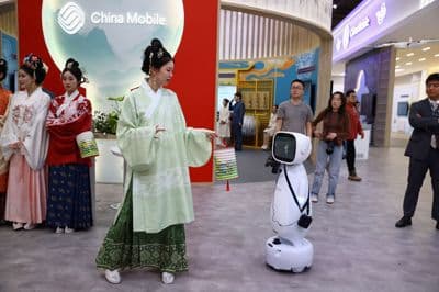 Ženska interagira z robotom družbe Xiaojia.