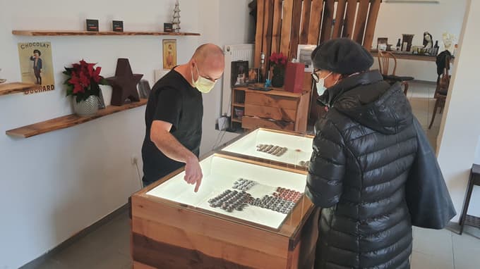 Lastnik čokoladnice strankam z vseljem da kakšen bonbon v pokušino. Foto: Hojka BERLIČ