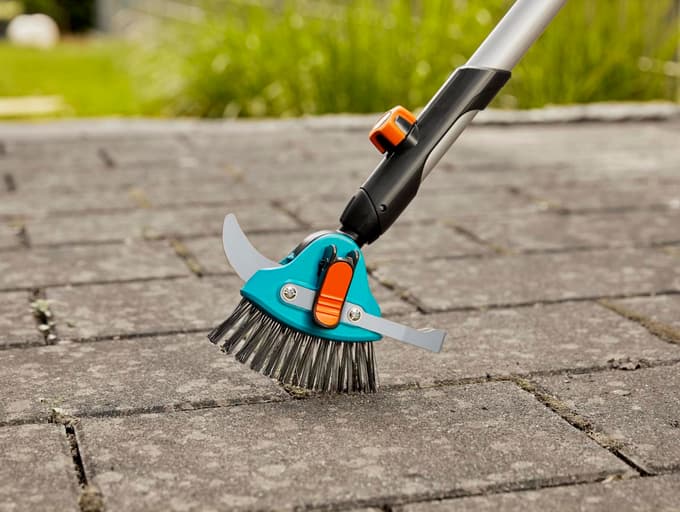 Večfunkcijsko orodje s kovinsko krtačo, lokom za širše reže in nožem je učinkovito pri odstranjevanju plevela med tlakovci.