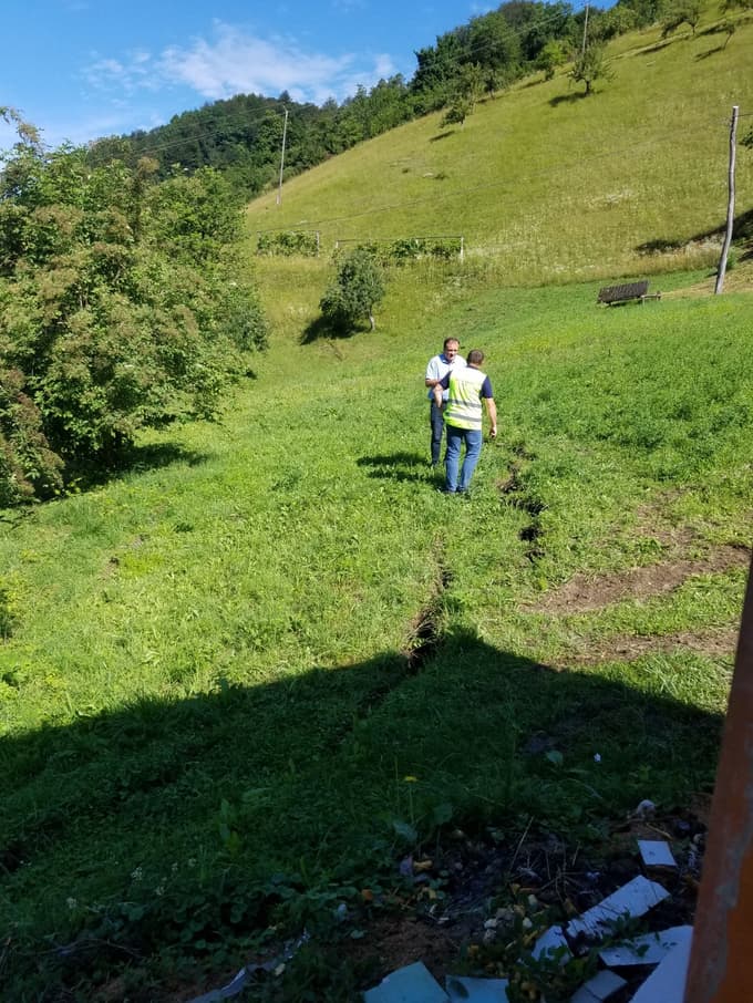 Laški župan Franc Zdolšek in poveljnik Civilne zaščite Matjaž Pikl si ogledujeta razpoke na pobočju.