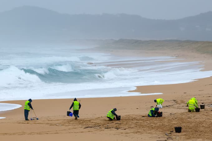 Skupina pobira plastične delce na plaži O Vilar beach v Galiciji.