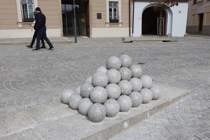 (FOTO) Na Vojašniškem trgu znova skulptura s topovskimi kroglami: So jih zdaj bolje pritrdili?