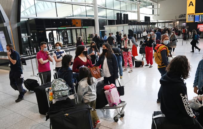 epa09382815 People queue for flights at Heathrow Airport in London, Britain, 31 July 2021. Britain is set to open its borders to double jabbed US and EU citizens from 02 August, the UK government has announced. EPA/ANDY RAIN