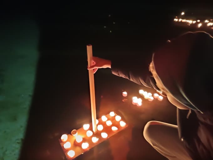 Polaganje svečk na jezeru Družmirje