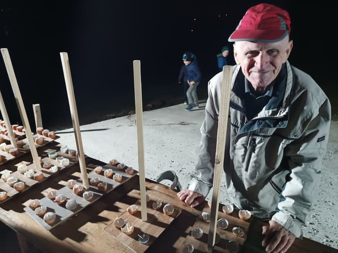 Polaganje svečk na jezeru Družmirje: večino svečk je izdelal Stane, član Turistično-olepševalnega društva Šoštanj