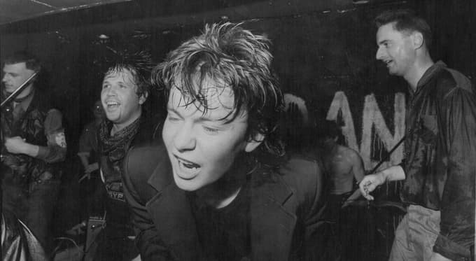 Andrej Košak na odru v svojem punk obdobju (zadaj Peter Lovšin in Peter Mlakar)