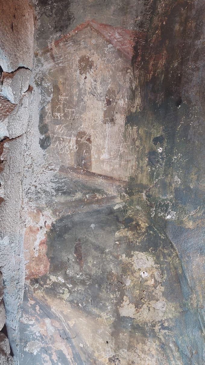 Detajl obraza moške figure in nad njo cerkvica