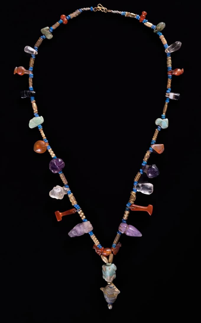 Ogrlice z amuleti, izrezljanimi iz različnih poldragih kamnov (karneol, ametist, kremen ...)