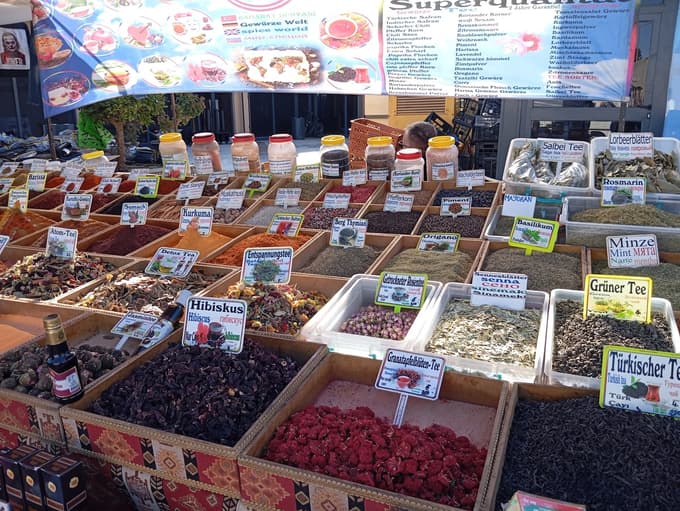 Stojnica z začimbami, čaji in suhim cvetjem na bazarju.