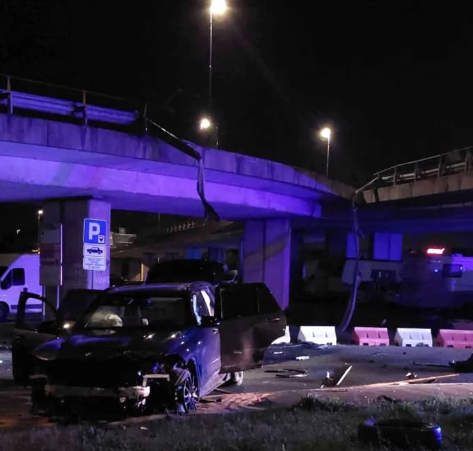 Na priključku na hitro cesto je voznik trčil v ograjo, jo odtrgal in padel na parkirišče nekaj metrov niže.