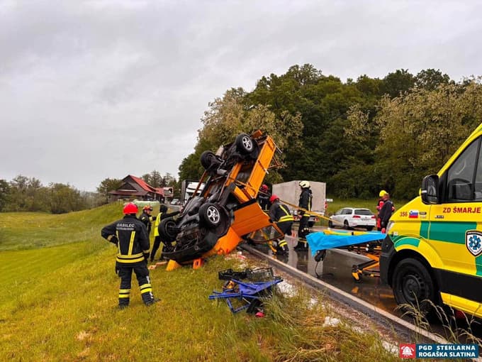 (FOTO) S tovornjakom trčil v semafor in se prevrnil na streho, iz vozila so ga reševali gasilci