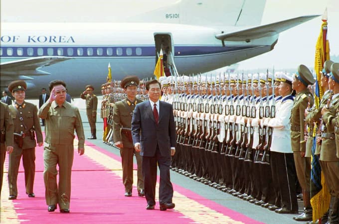 Severnokorejski voditelj Kim Džong Il (v ospredju levo) in južnokorejski predsednik Kim Dae Džung pregledata častno stražo med pozdravno slovesnostjo na letališču Sunan v Pjongjangu 13. junija 2000. Bil je čas otoplitve odnosov.