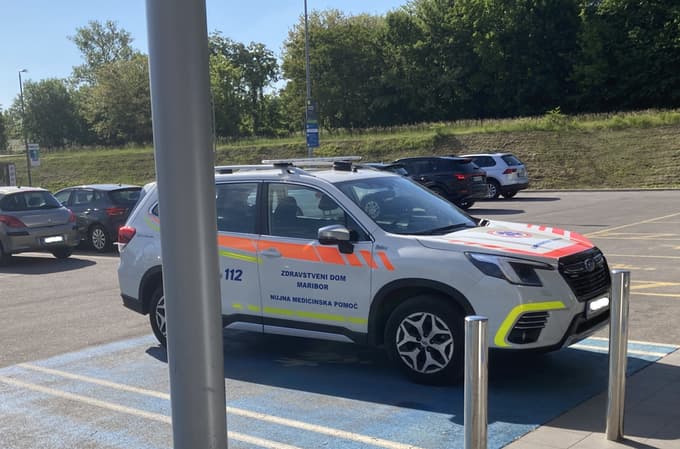 Vozilo urgentnega zdravnika na parkirnem mestu, namenjenem staršem z majhnimi otroki in nosečnicam.