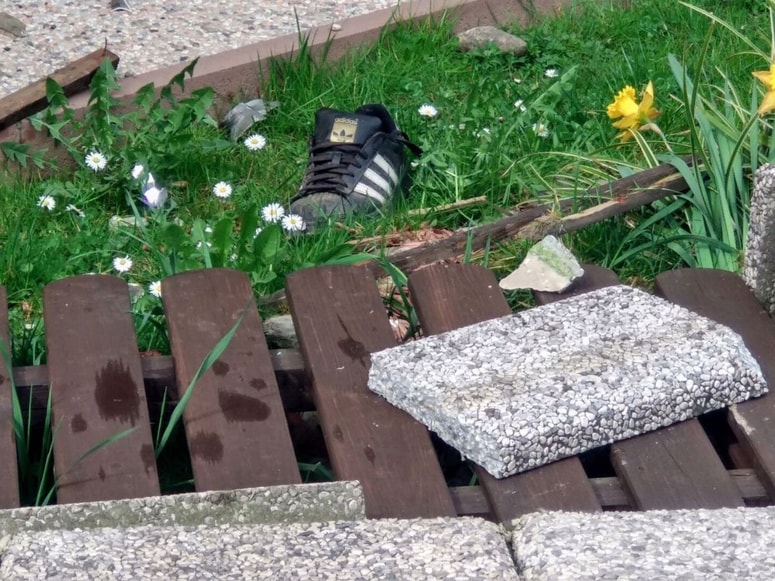 Obuvalo ponesrečenca je obležalo med razbitinami ograje, v katero je v Adamičevi ulici v Mariboru trčila 25-letna voznica. Foto: Tomaž KLIPŠTETER/DNEVNIK
