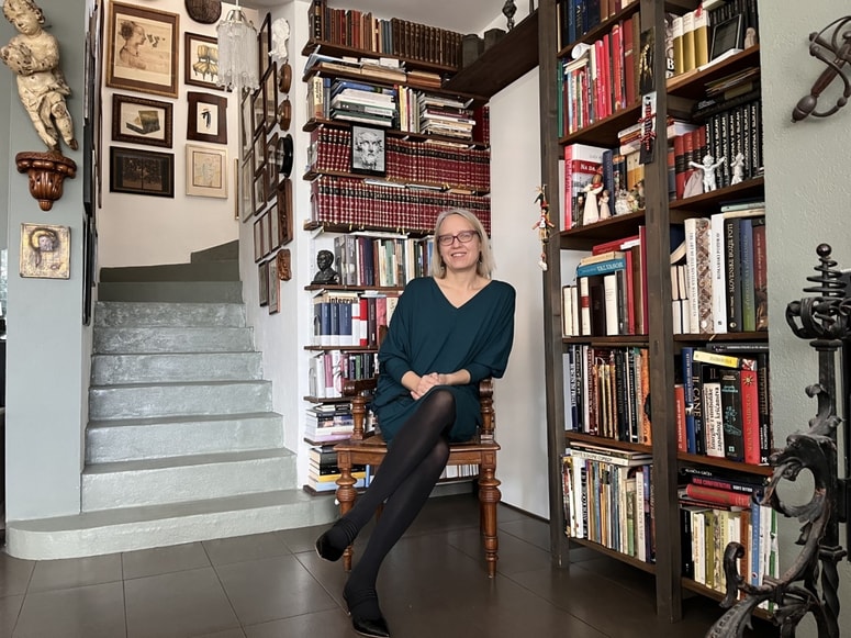 Ksenija Horvat v domačem knjižnem kotičku. Na vidnem mestu so tudi številna dela prekmurskih avtorjev in o Prekmurju. 
