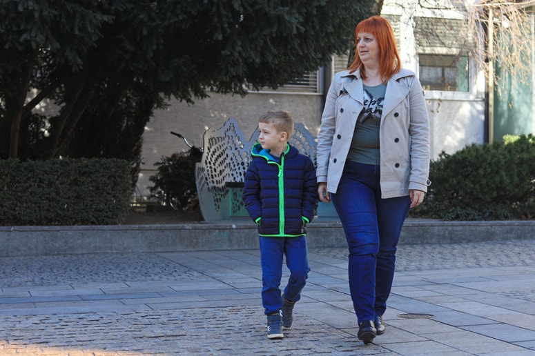 Nataša Vrbnjak Šteflič z Galom, ki ima dve spodnji kosti v roki zaraščeni skupaj. Deček se zaveda svoje pomanjkljivosti, zato rokice pogosto skriva v žep. 