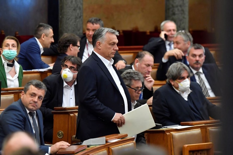 Viktor Orban med poslanci madžarskega parlamenta, ki so od ponedeljka le še privesek demokracije. Ko so mu nekateri kritiki očitali, da Madžarsko spreminja v kronsko diktaturo - korona v prevodu pomeni krona -, jim je odgovoril, da madžarska ustava kronanja še ne predvideva. 