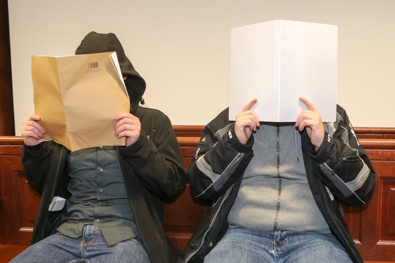 Obtožena sta pred fotoreporterjem skrivala obraz. 