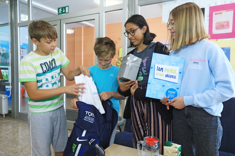 Luka Bratuša, petošolec iz OŠ Martina Konšaka, je Tom nahrbtnik prinesel osnovnošolcem OŠ Slave Klavore. Sprejeli so ga Vidjan Kure Unger, Medina Rizvanaj in Sarah Suljić. 
