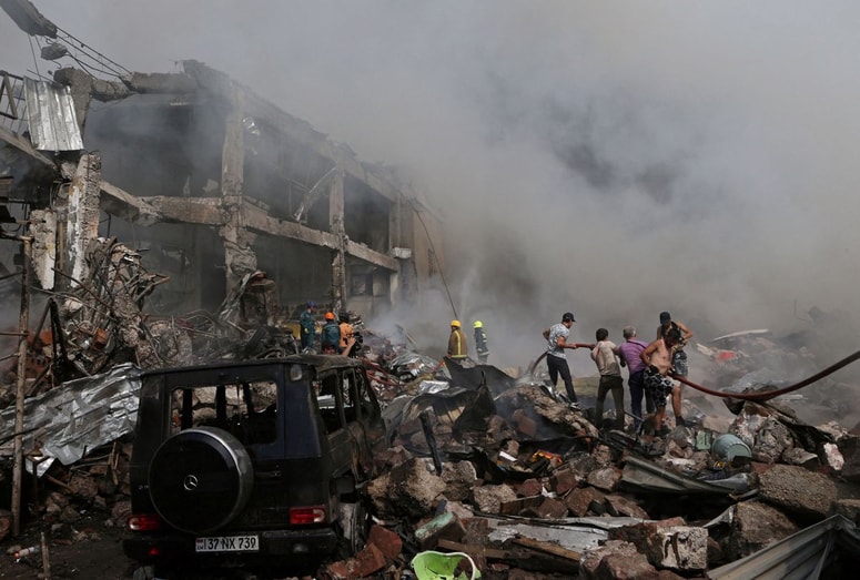People help firefighters to extinguish a fire after blasts ripped through a fireworks warehouse in a shopping mall in Yerevan, Armenia August 14, 2022. Vahram Baghdasaryan/Photolure via REUTERS ATTENTION EDITORS - THIS IMAGE HAS BEEN SUPPLIED BY A THIRD PARTY. TPX IMAGES OF THE DAY 