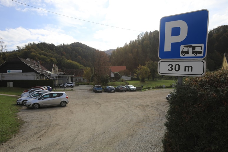 Gramoznato parkirišče ob Falski cesti, kjer vozniki parkirajo, da lahko gredo v lekarno, na pošto, tudi do cvetličarne, okulista, zadruge, mesnice, v župnišče.