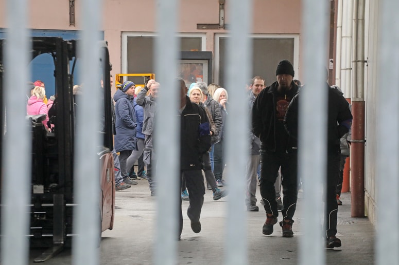 Več kot 90 zaposlenih A&E Europe je na dvorišču tovarne mirno protestiralo. 