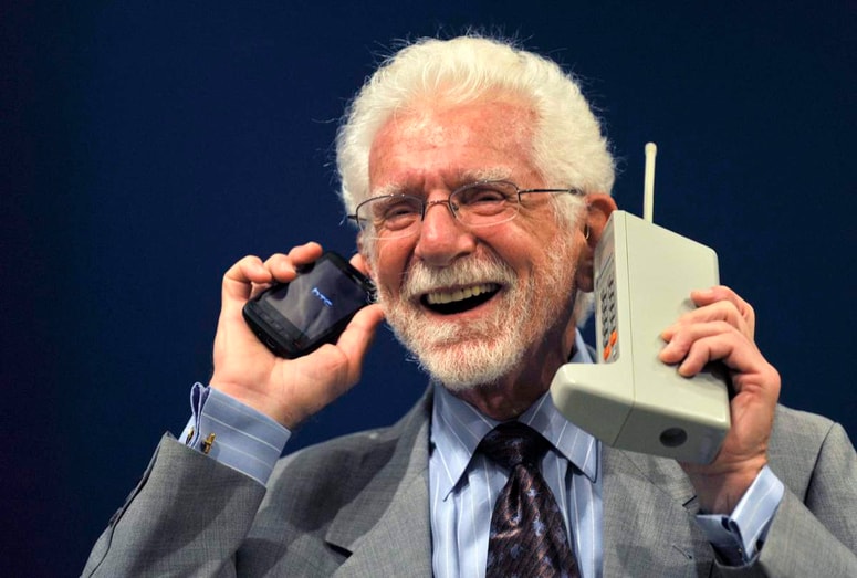 Ameriški inženir in izumitelj Martin Cooper z mobilnim telefonom Motorola DynaTAC, ki je bil prvi komercialni mobilnik na svetu.