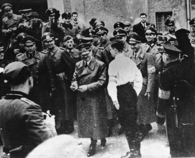 Ob odhodu iz mariborskega gradu je Adolfa Hitlerja pozdravil pripadnik Nemške mladine, 26. april 1941. Fotografijo hrani Muzej narodne osvoboditve Maribor. 