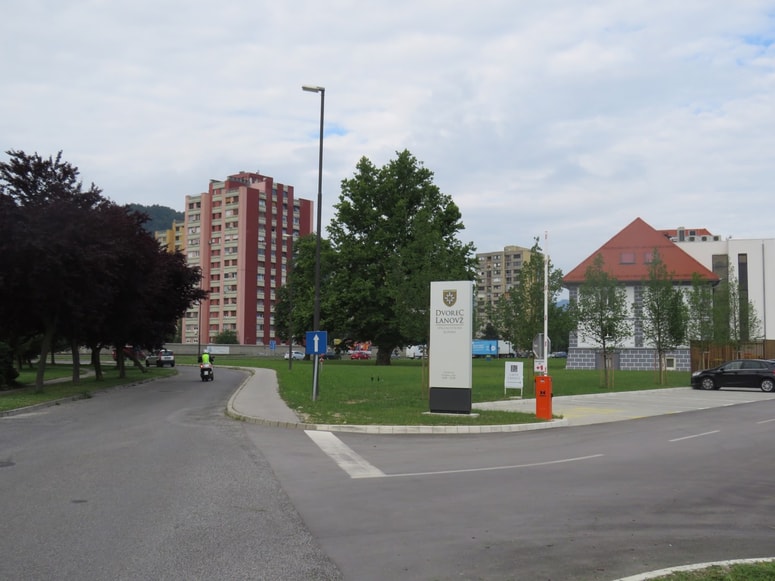 Okolica vhoda v prenovljeni dvorec Lanovž z urejenim parkirnim prostorom 