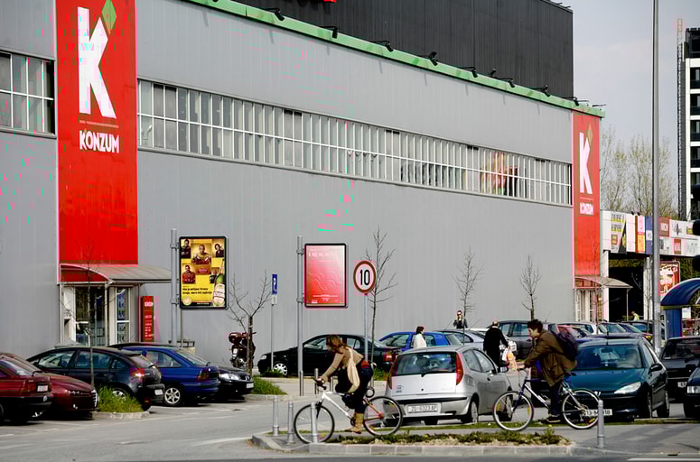 Moški je sedel v avtomobilu na parkirišču pred trgovino. Fotografija je simbolična.