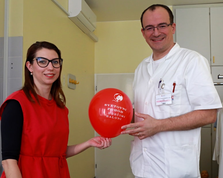 Petra Greiner in Faris Mujezinović z rdečim balonom, simbolom pohoda ob dnevu redkih bolezni 