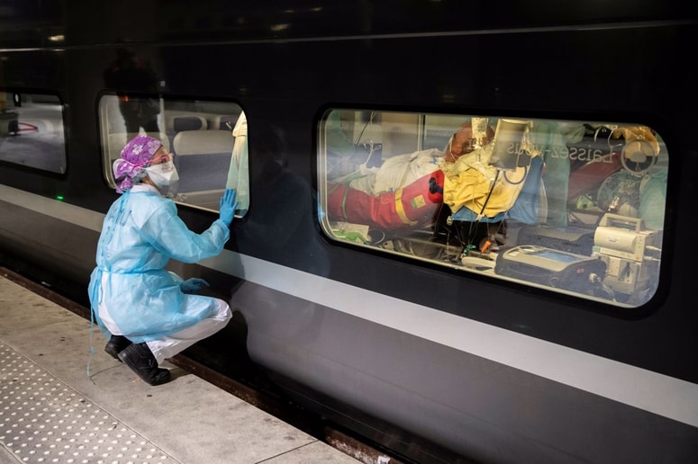 Medicinsko osebje opazuje transport pacienta s covid-19. 