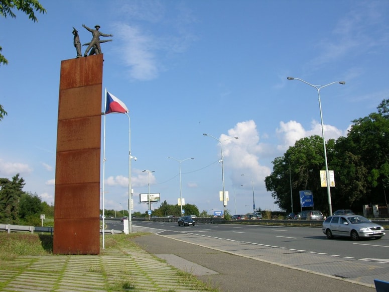 Spomenik na prizorišču atentata na Heydricha, ki je ranam podlegel čez cesto v še vedno obstoječi bolnišnici.