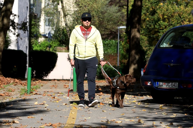 Timotej Skledar v družbi Baste, izšolanega psa vodnika
 