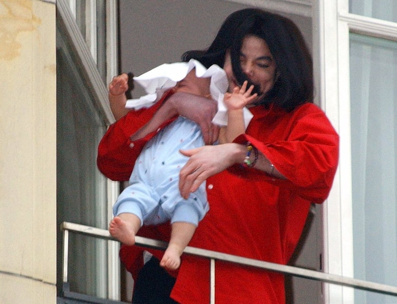 Prizor, ki je pretresel svet. Evforični Michael Jackson je leta 2002 sina javnosti pokazal kar čez ograjo berlinskega hotela.   