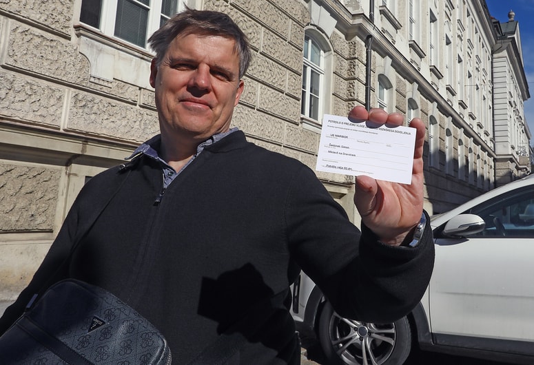 Simon Šerbinek pri mariborski upravni enoti s kartončkom, da ima podaljšano vozniško dovoljenje 