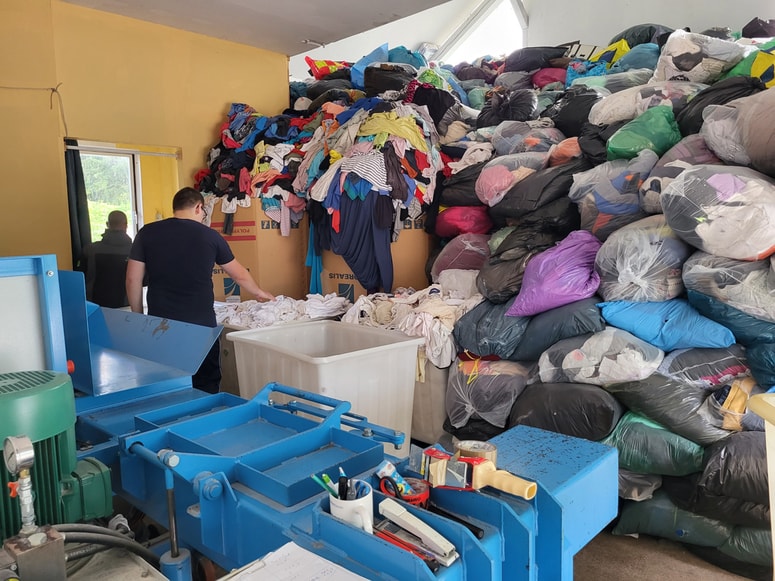 Zadruga Dobrote: Ko oblačila zberejo, jih pregledajo in razvrstijo, najprej pa odstranijo popolnoma neuporabna.