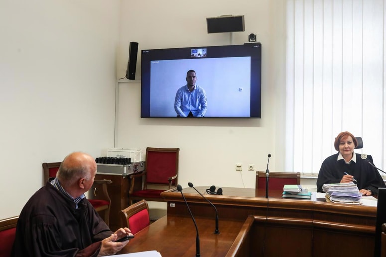 Zaradi kadrovske problematike v zaporih Alena Grdinića niso pripeljali na sodišče. Narok je spremljal preko videopovezave. 