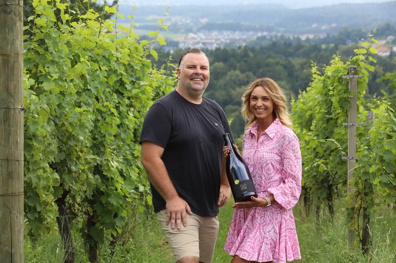 Gregor in Tjaša Mikuž s steklenico nagrajenega sauvignona v enem od svojih vinogradov v Radizelu