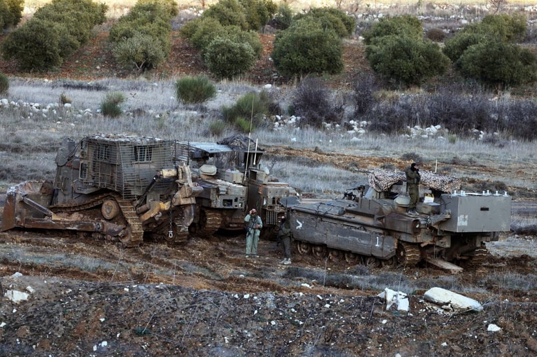 Izraelski vojaki ob vojaških buldožerjih in vozilih na zasedenih območjih v Siriji.