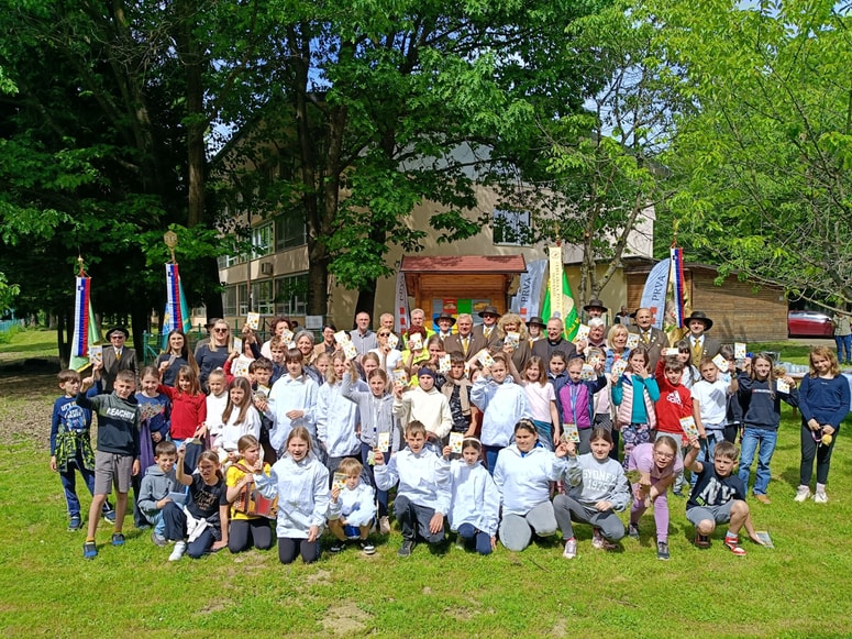 Otroci, učitelji in predstavniki čebelarskih društev in zvez pred novim učnim čebelnjakom. 