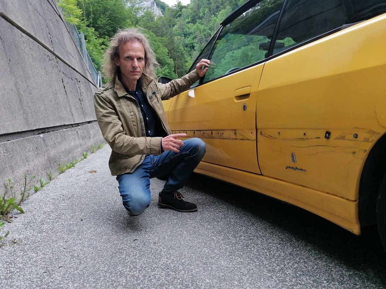 Uroš Zavodnik ob svojem vozilu, ki ga je poškodoval medved.