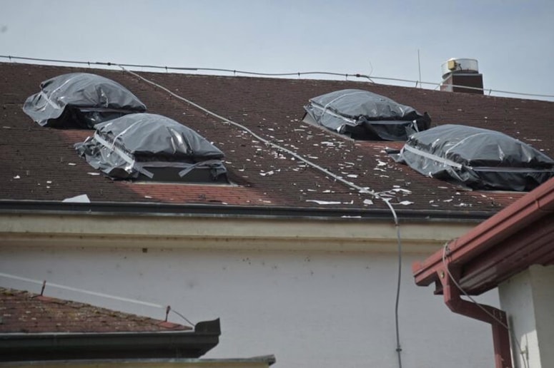 Poškodovana strešna okna so za prvo silo zaščitili s folijo. 