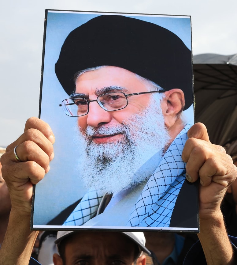 Protestnik drži portret iranskega vrhovnega voditelja Alija Hameneja.