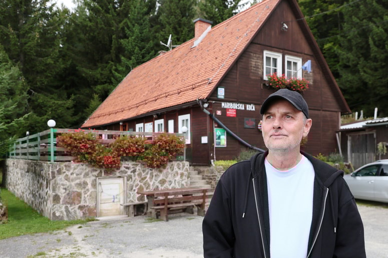 Iztok Brodnjak, novi oskrbnik, na dvorišču Mariborske koče, ki ima že več kot stoletno zgodovino 