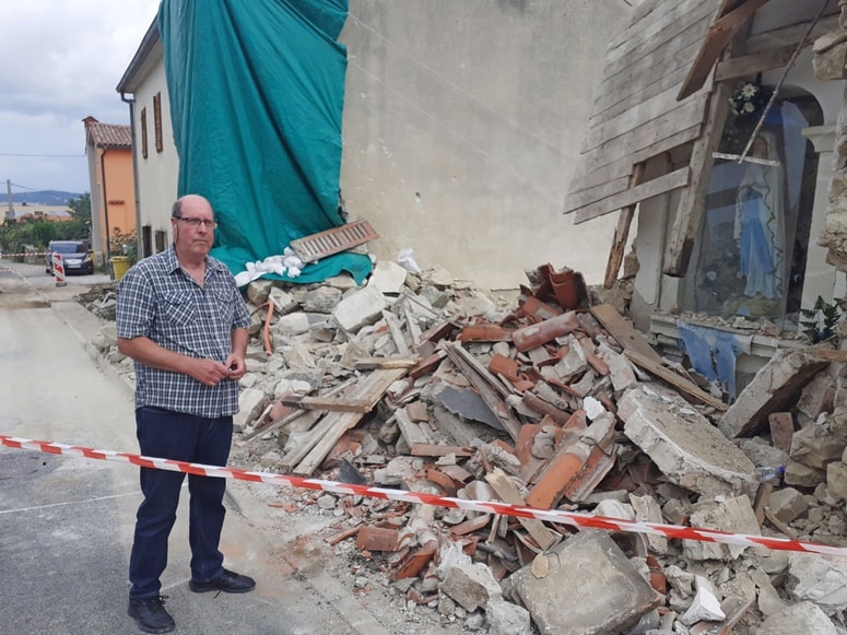 Dorjan Muženič ob ruševinah kapelice in vogala svoje hiše.