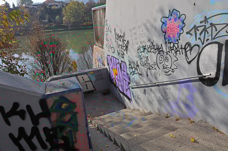 Na stopnišču, ki povezuje pešpot ob Dravi z bloki na Koroški cesti, je veliko grafitov. 