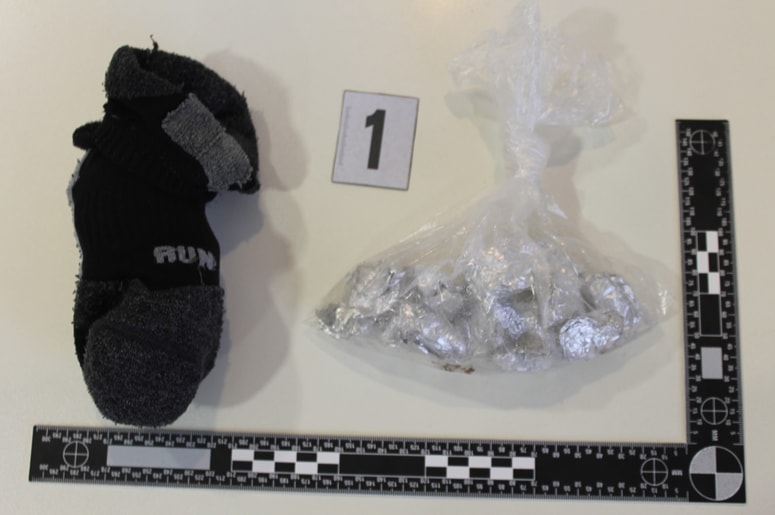 Nogavica in vrečka z drogo, ki ju je med begom odvrgel povzročitelj prometne nesreče na Šmartinski cesti v Ljubljani 